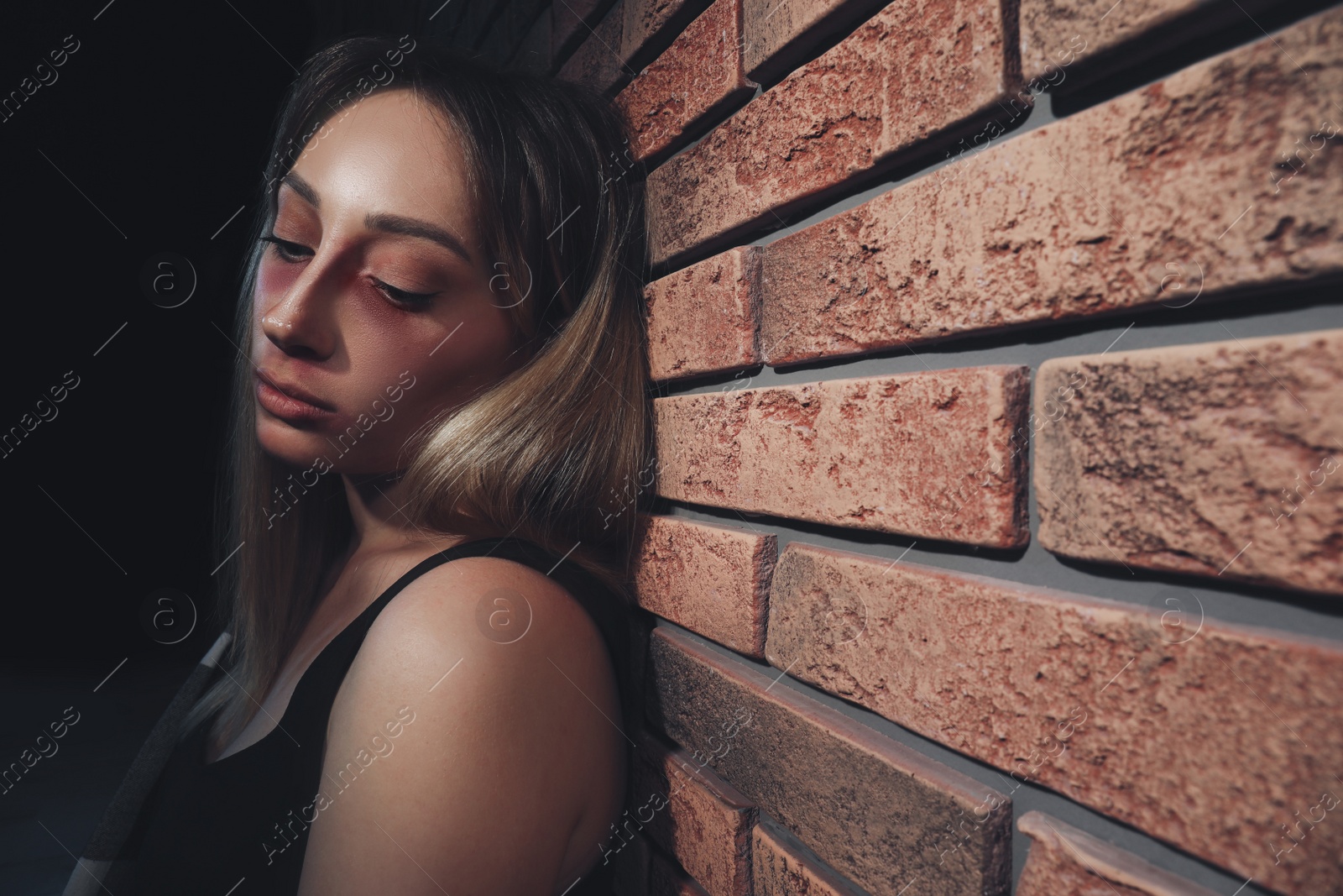 Photo of Overdosed drug addicted woman near brick wall. Space for text