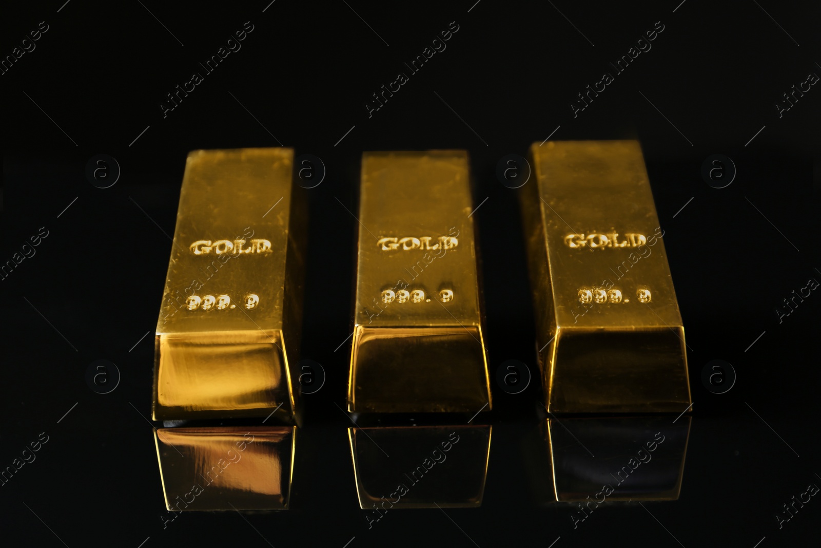 Photo of Precious shiny gold bars on black background