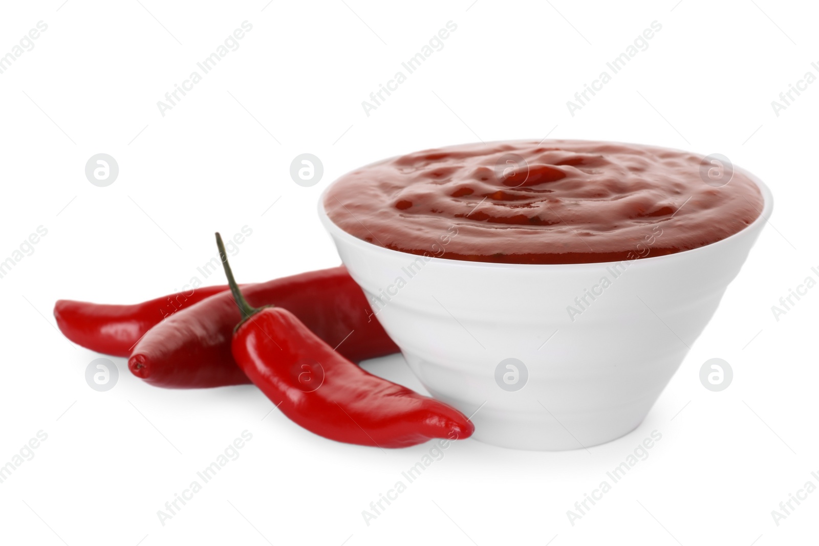 Photo of Bowl with red sauce and fresh chili peppers isolated on white