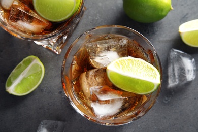 Photo of Glass of refreshing drink with ice cubes and lime on table, top view