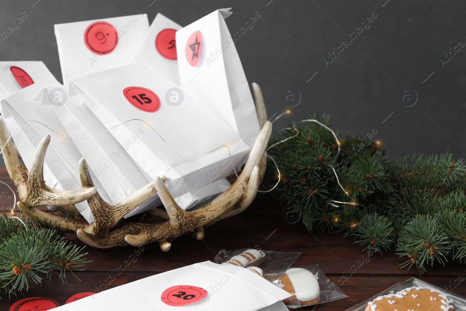 Photo of Gift bags, Christmas cookies and fir tree on wooden table. Creating advent calendar