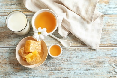 Beautiful composition with milk and honey on wooden background, top view