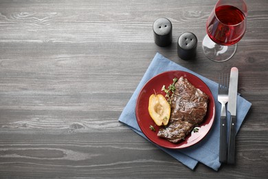 Delicious roasted beef meat and caramelized pear served on grey wooden table, flat lay. Space for text