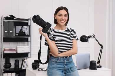 Young professional photographer with camera in modern photo studio