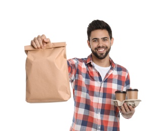 Photo of Young courier with paper bag and drinks on white background. Food delivery service