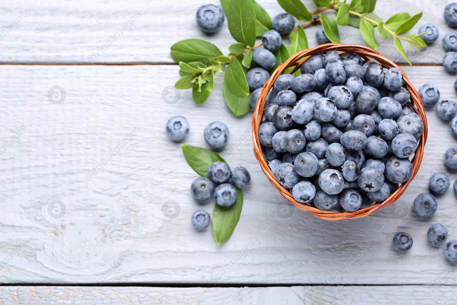 Photo of Tasty fresh blueberries on wooden table, flat lay. Space for text