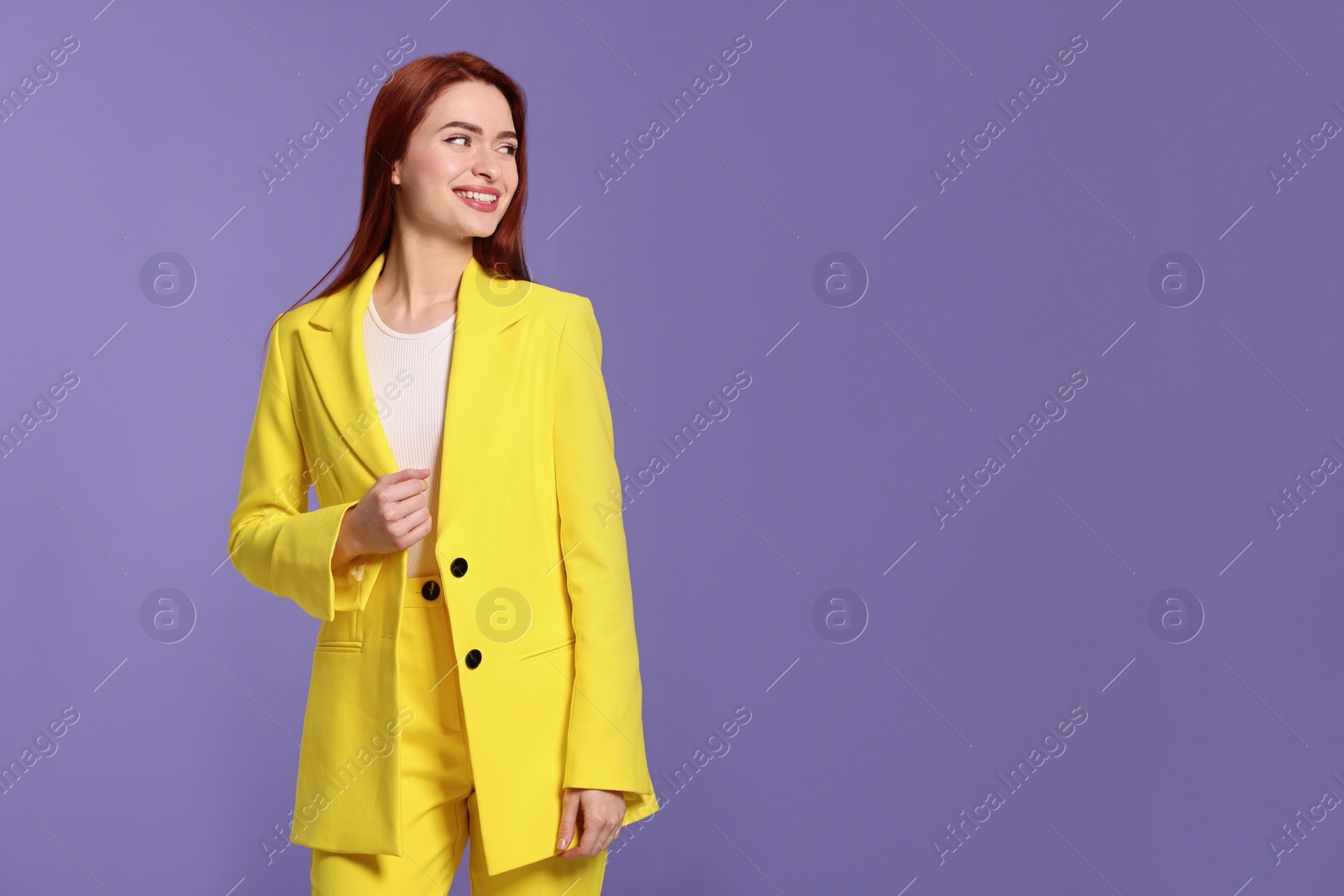 Photo of Happy woman with red dyed hair on purple background, space for text