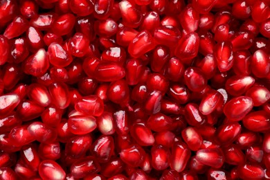 Photo of Tasty pomegranate seeds as background, top view