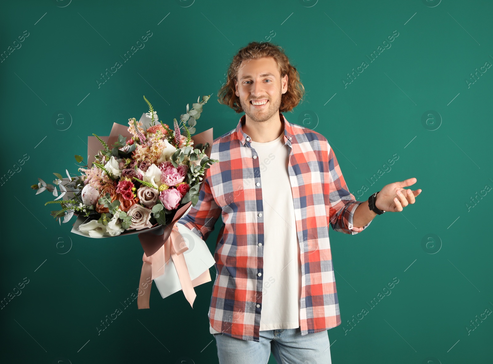 Photo of Young handsome man with beautiful flower bouquet on green background