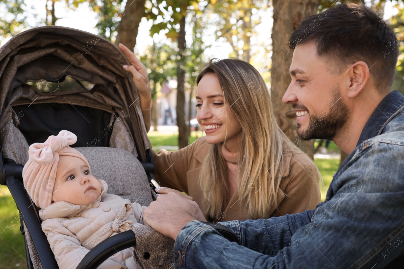 Photo of Happy parents with their baby in park on sunny day