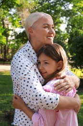 Mature woman with her little granddaughter in park