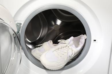 Photo of Stylish clean sneakers inside modern washing machine