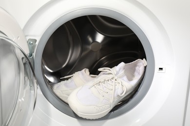 Stylish clean sneakers inside modern washing machine