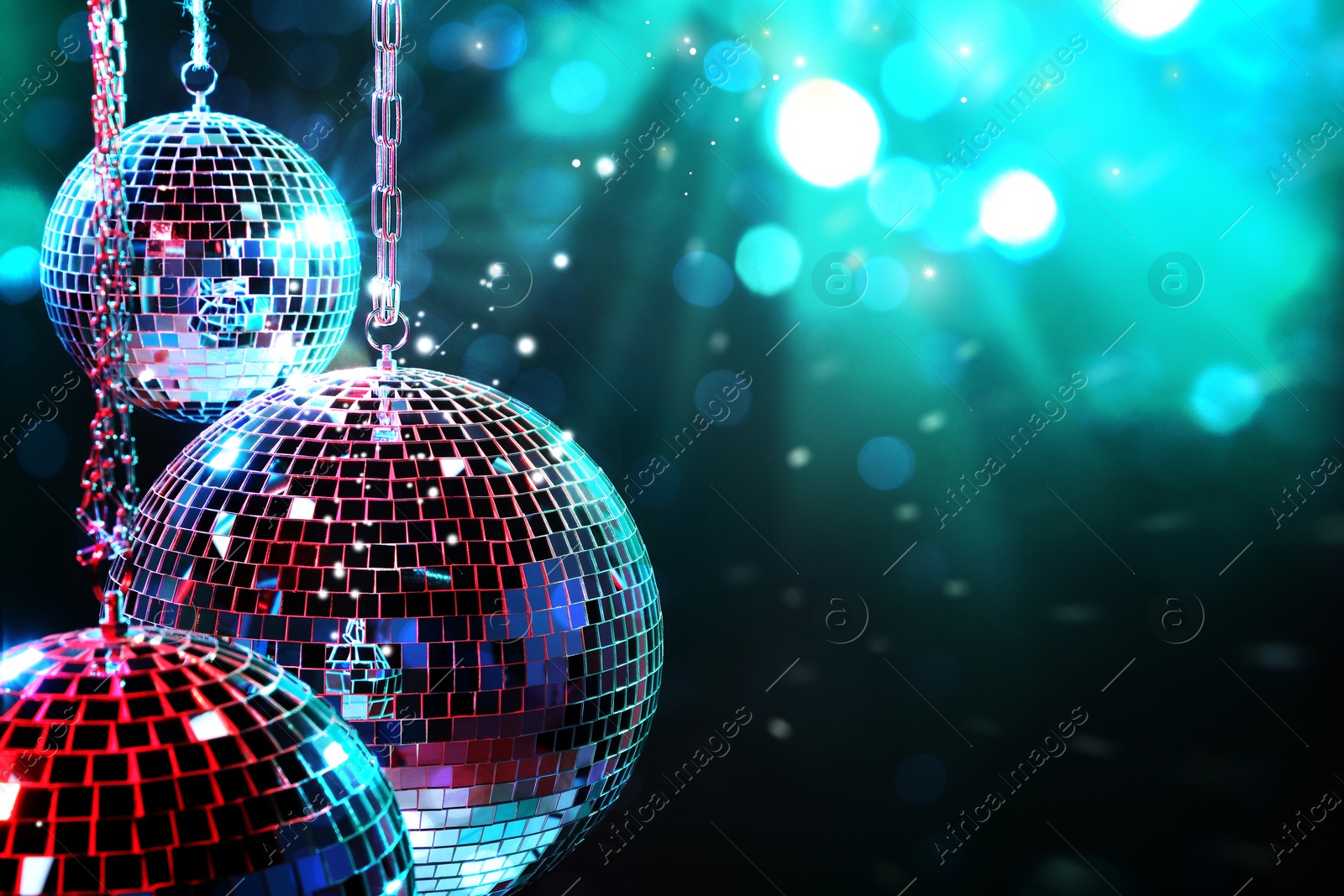 Image of Shiny disco balls on dark cyan background with blurred lights, space for text. Bokeh effect