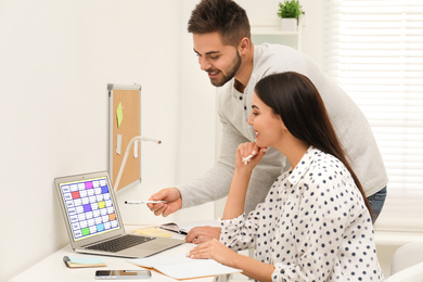 Photo of Colleagues working with calendar app on laptop in office