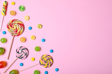 Photo of Bright yummy candies and space for text on color background, top view