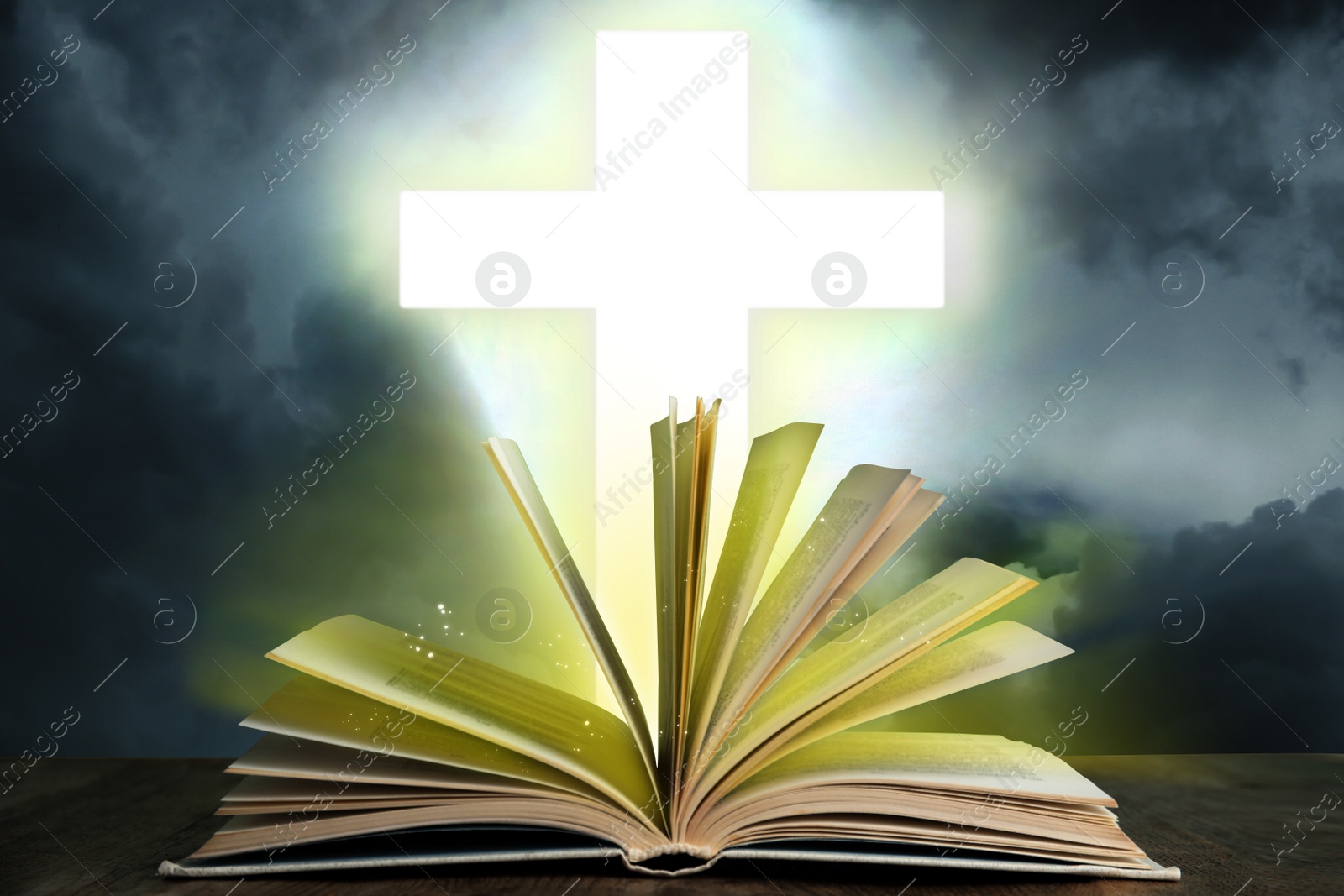 Image of Silhouette of cross and open Bible on grey table against cloudy sky