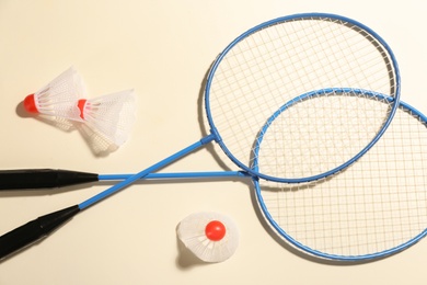 Photo of Badminton rackets and shuttlecocks on light background, flat lay