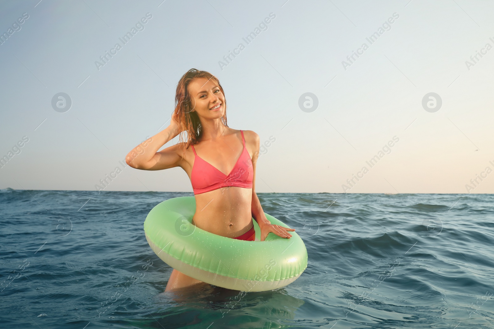 Photo of Beautiful woman with inflatable ring in sea