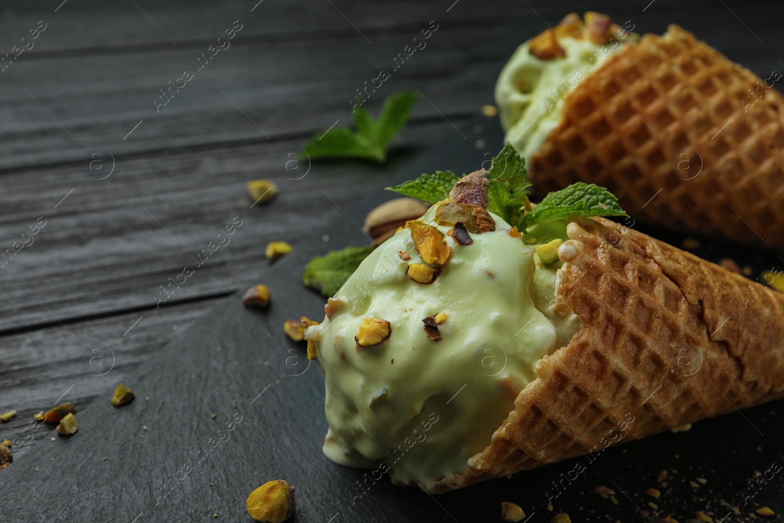 Photo of Delicious green ice cream served on wooden table, closeup. Space for text