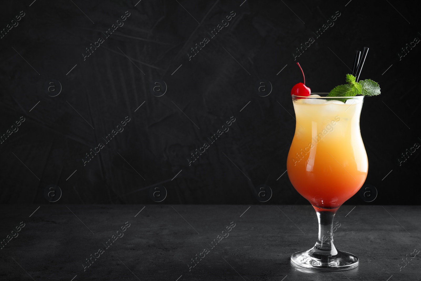 Photo of Just made appetizing cocktail Sex on the Beach, black background. Space for text