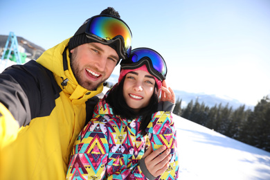 Photo of Young couple taking selfie at ski resort. Winter vacation