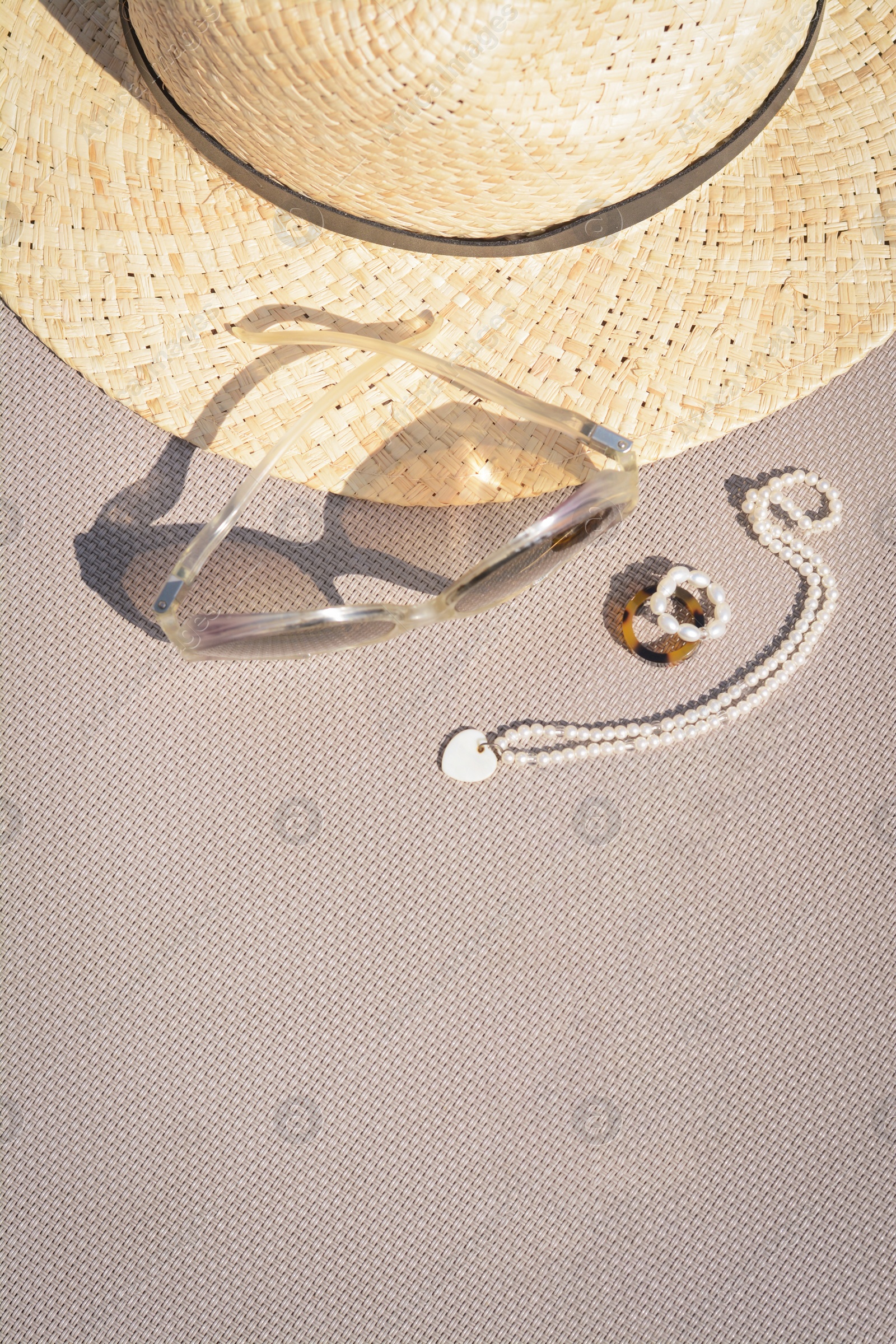 Photo of Stylish hat, sunglasses and jewelry on grey surface, flat lay. Space for text