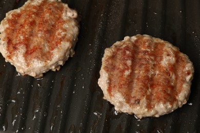 Cooking tasty hamburger patties on grill pan, closeup