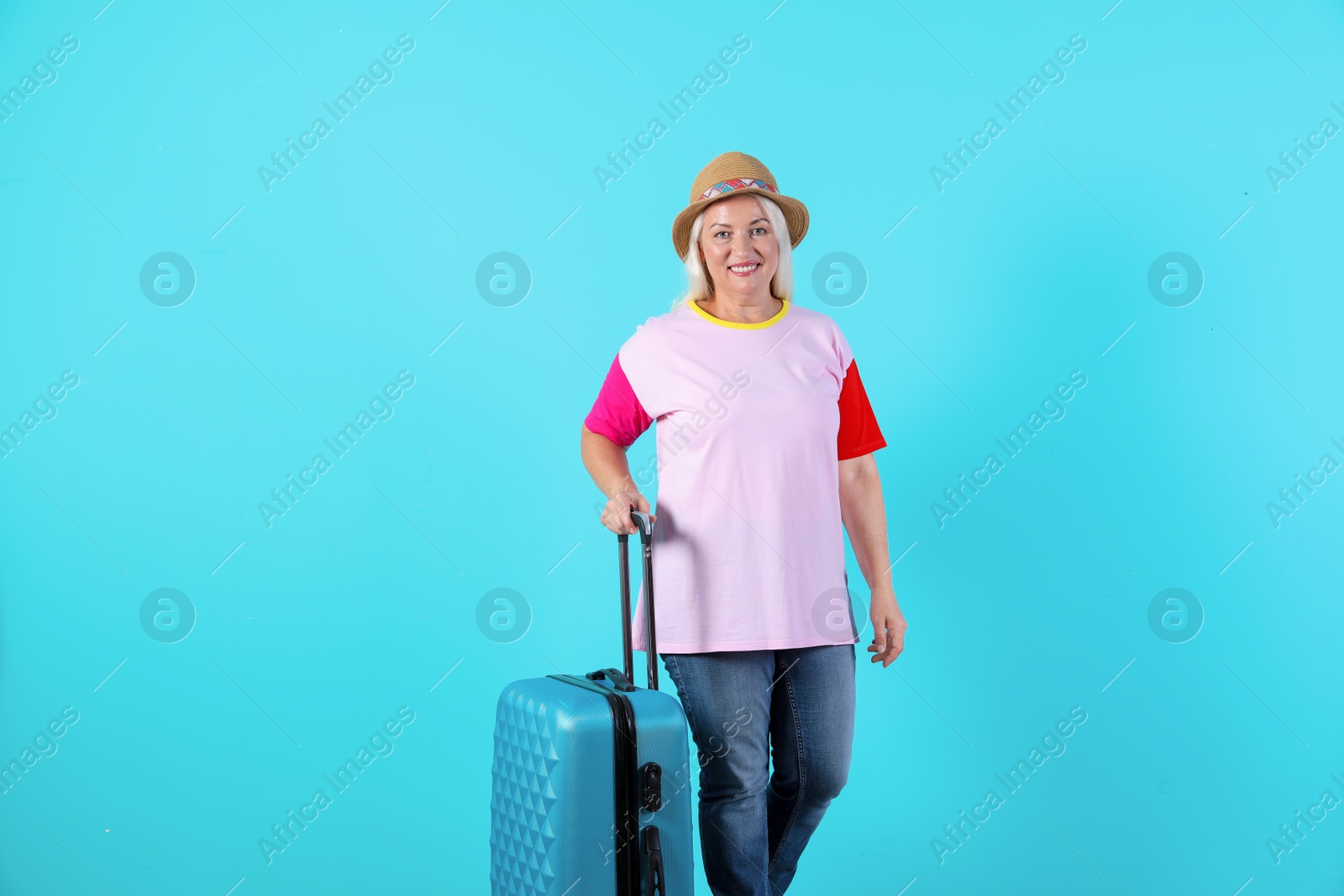 Photo of Senior woman with suitcase on color background. Vacation travel