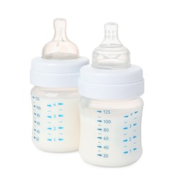 Two feeding bottles with infant formula on white background