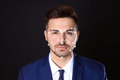Image of Facial recognition system. Businessman with digital biometric grid on dark background