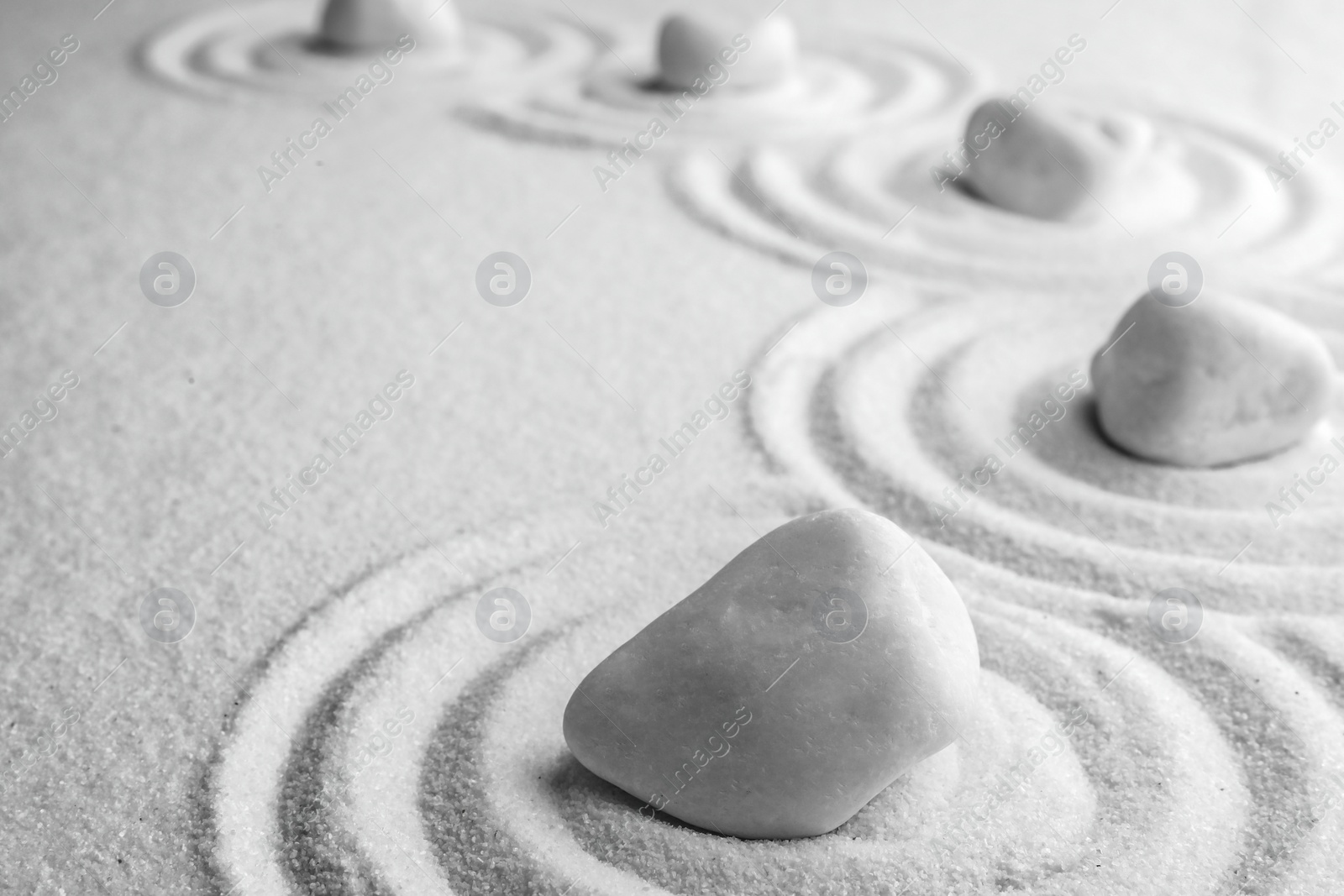 Photo of White stones on sand with pattern, space for text. Zen, meditation, harmony