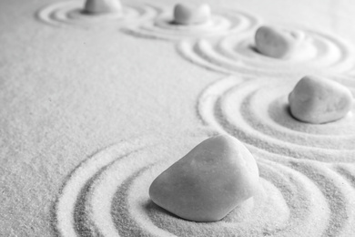 Photo of White stones on sand with pattern, space for text. Zen, meditation, harmony