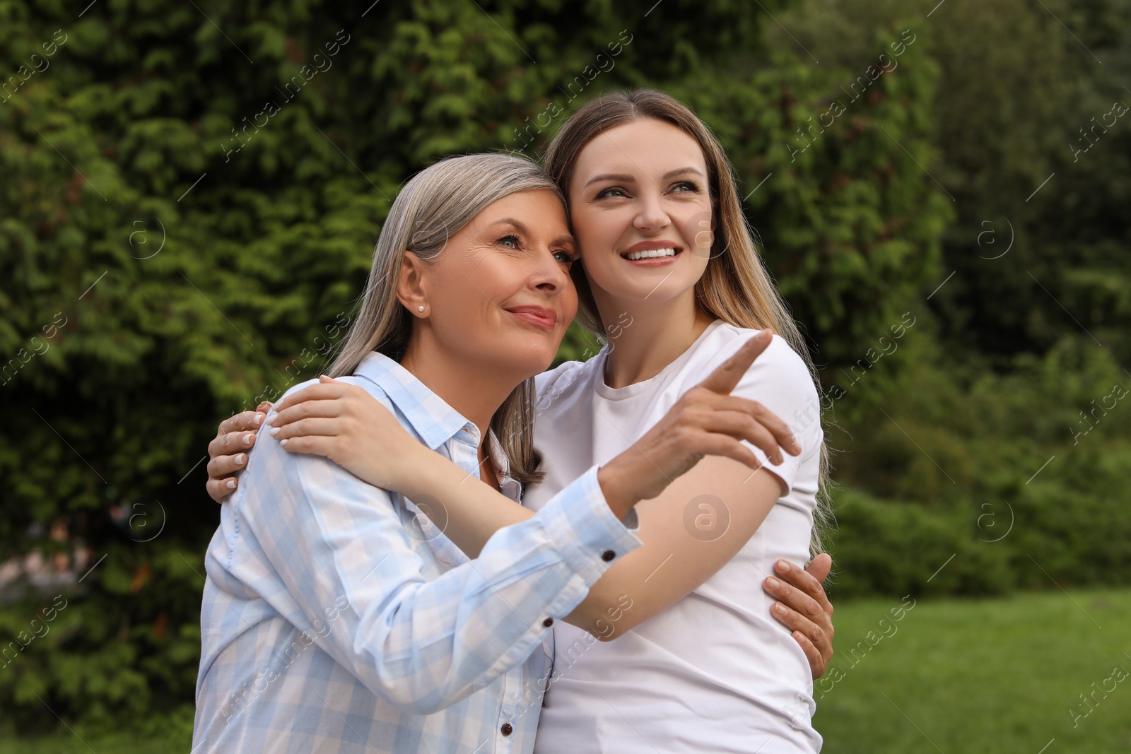 Photo of Happy mature mother and her daughter hugging in park