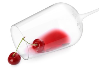 Photo of Overturned glass of delicious cherry wine and ripe juicy berries isolated on white