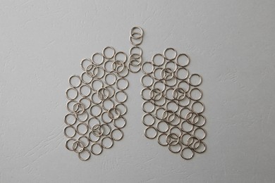 Human lungs made of metal rings on grey textured table, flat lay