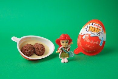 Slynchev Bryag, Bulgaria - May 25, 2023: Kinder Joy Egg with sweet candies and toy on green background