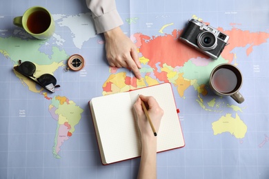 Photo of Women planning vacation on world map, top view with space for text. Travel agency