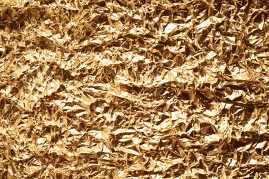 Crumpled gold foil as background, top view