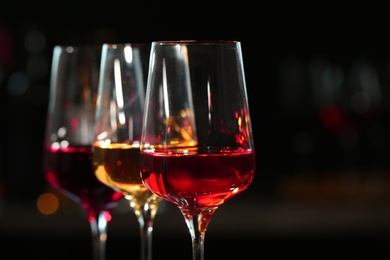 Photo of Row of glasses with different wines against blurred background, closeup. Space for text