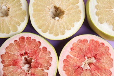 Photo of Fresh cut pomelo fruits on lilac background, flat lay