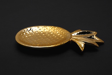 Photo of Gold pineapple shaped bowl on black background