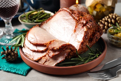 Photo of Delicious Christmas ham served with garnish on table