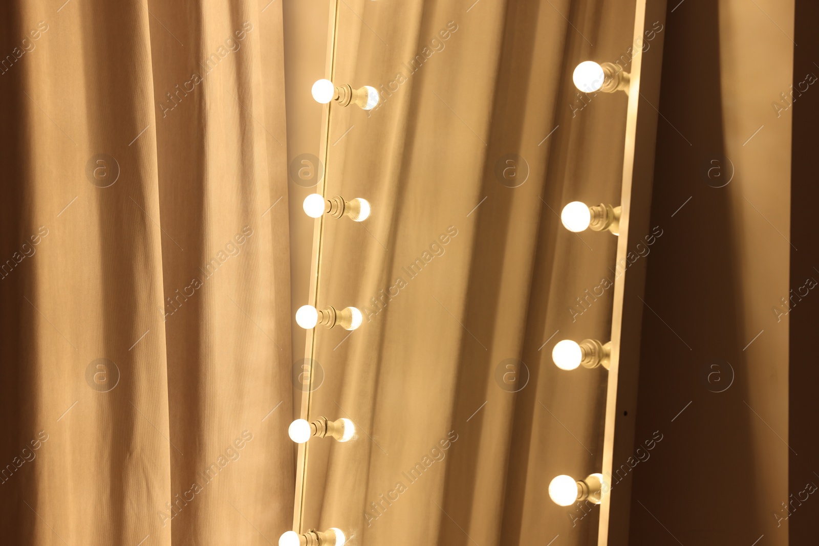 Photo of Modern mirror with light bulbs in makeup room, closeup