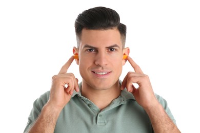 Man inserting foam ear plugs on white background
