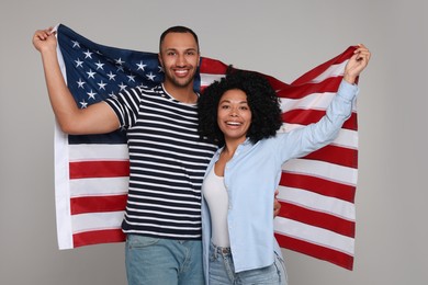 Photo of 4th of July - Independence Day of USA. Happy couple with American flag on grey background