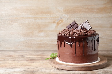 Photo of Freshly made delicious chocolate cake on wooden table. Space for text