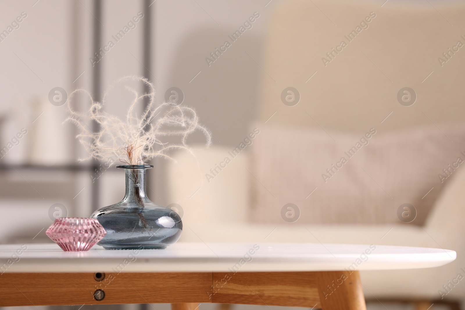 Photo of Vase with dried plant and candle on white table in living room, space for text