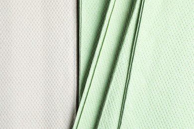 Photo of White and green paper napkins as background, closeup