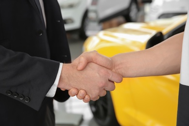 Young man buying car in salon